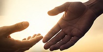 An outstretched hand reaching toward another in support.